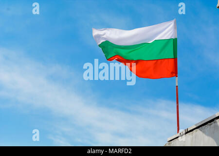 Bandiera bulgara agitando contro vibrante blu cielo Foto Stock