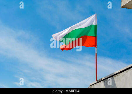 Bandiera bulgara agitando contro vibrante blu cielo Foto Stock