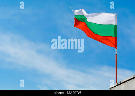 Bandiera bulgara agitando contro vibrante blu cielo Foto Stock