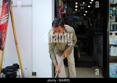 Bangalore, India - 20 Ottobre 2016: Sconosciuto uomo musulmano di pulizia inizia il suo negozio alla strada commerciale di questa mattina. Foto Stock