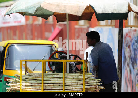 Bangalore, India - 20 Ottobre 2016: Sconosciuto street lato venditore di estrarre il succo dalla canna da zucchero nella zona Shivajinagar. Foto Stock