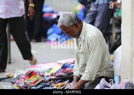 Bangalore, India - 20 Ottobre 2016: Sconosciuto venditore di calzature in streetsides del mercato Shivajinagar. Foto Stock