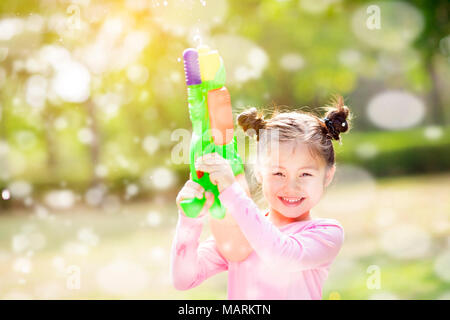 Felice bambine giocando pistole acqua nel parco Foto Stock