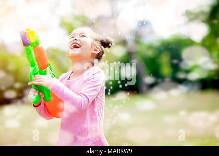 Felice bambine giocando pistole acqua nel parco Foto Stock