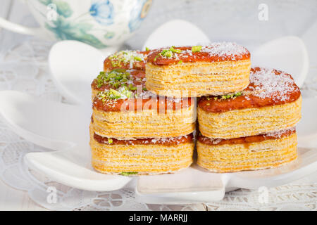 Gruppo luce di croccante di sfoglia di pasta a strati guarnito con pistacchi e scaglie di cocco popolare dolci persiano In Iran chiamato Zaboon o Zaban Foto Stock