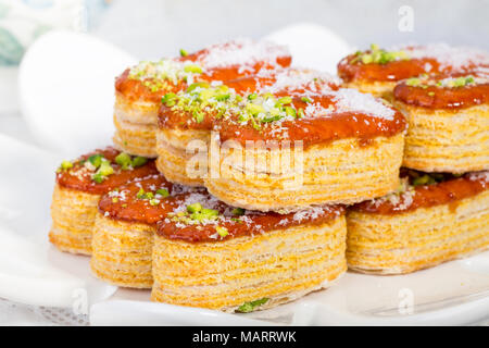 Gruppo luce di croccante di sfoglia di pasta a strati guarnito con pistacchi e scaglie di cocco popolare dolci persiano In Iran chiamato Zaboon o Zaban Foto Stock