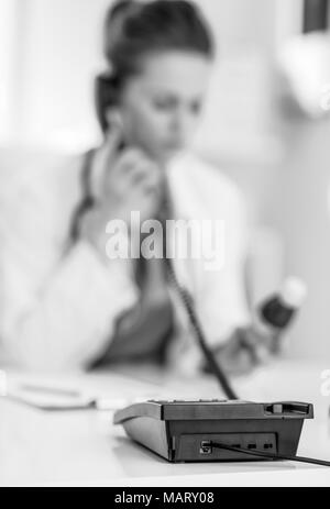 Primo piano sul medico donna con bottiglia di medicina parlando telefono Foto Stock