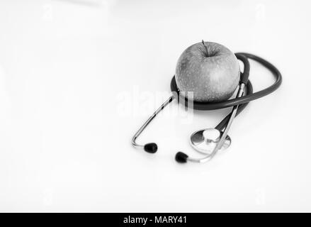 Primo piano su uno stetoscopio e apple sul tavolo Foto Stock