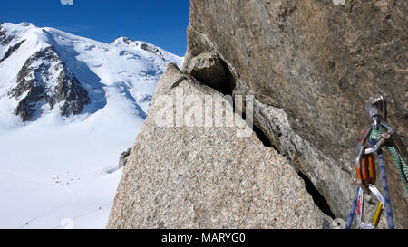 Bullone e quick draw con arrampicata attrezzature su un esposto e ripido percorso di arrampicata nelle Alpi Francesi con Mont Blanc in background Foto Stock