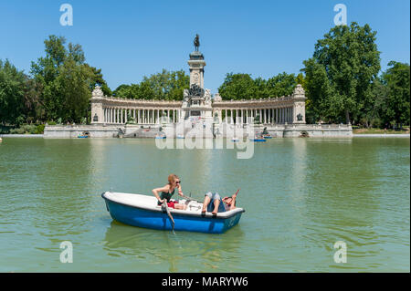 Giovani donne avendo divertimento per le gite in barca sul lago del Parco del Buen Retiro, Madrid, Spagna Foto Stock