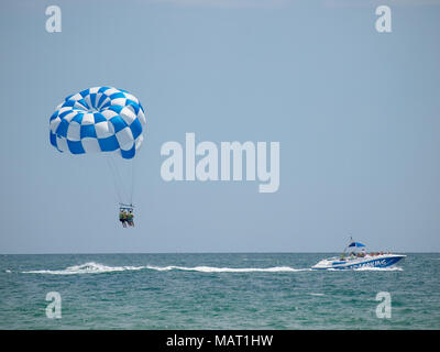 Blu ala parasail tirata da una barca in acqua di mare, Parasailing noto anche come parascending o parakiting Foto Stock