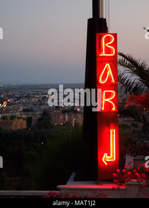 Illuminati al neon bar segno con la freccia. La Bulgaria città in background Foto Stock