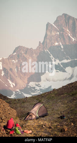 Piccola tenda e un alpine/montagna campeggio nelle montagne costiere della Columbia Britannica (Canada). Magestic picco di montagna in background. Foto Stock