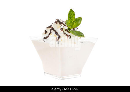 Gelato dessert con panna montata, isolato su uno sfondo bianco in basso in vetro trasparente con le foglie di menta e cioccolato topping, salsa. Il dessert f Foto Stock