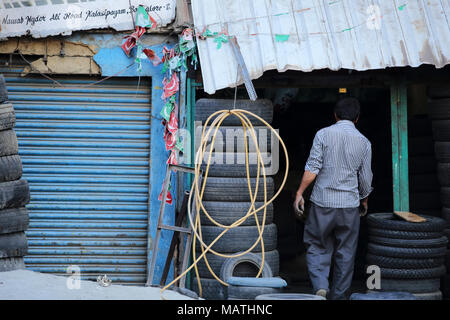 Bangalore, India - 23 Ottobre 2016: Un uomo sconosciuto inserendo il suo piccolo negozio di pneumatici a Kalasipalyam area in Bangalore. Foto Stock