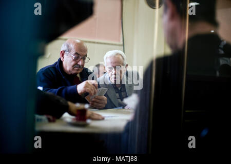 ISTANBUL, Turchia - 7 Novembre 2009: l'uomo guarda oltre la spalla di un altro giocando a carte all'interno di un cafe nel quartiere Fatih di Istanbul. Foto Stock