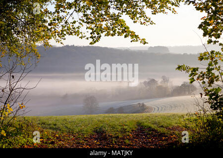 Strati di mattina presto nebbia nella Wylye Valley, Wiltshire, visto dalla collina Cotley vicino Heytesbury. Foto Stock