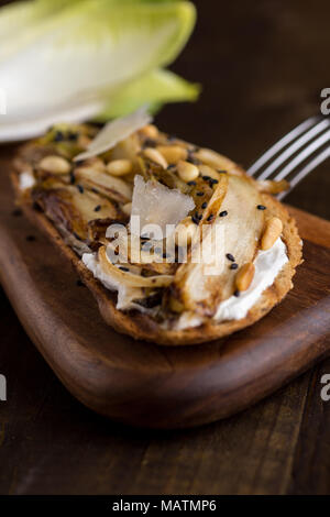 Arrosto cicoria organico sulla fetta di pane con pinoli e sesamo nero. Organici di cibo sano. Foto Stock