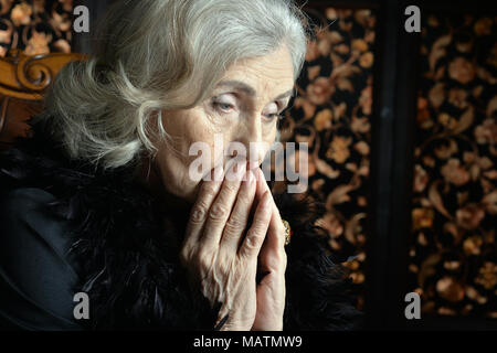 Ritratto di triste donna senior in boa in posa Foto Stock