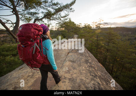 Una femmina di escursionista esplorare ponticello del cielo nella Red River Gorge di KY a sunrise. Foto Stock