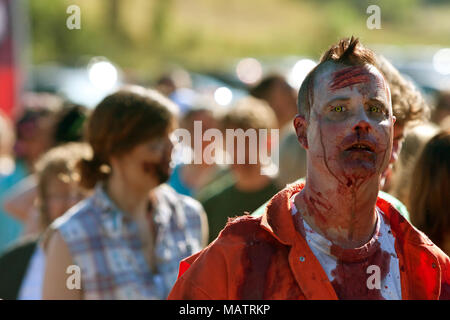 Una sanguinosa zombie maschio attende di essere spruzzato con più sangue finto così egli può terrorizzare i corridori in uno zombie esecuzione in Dalton, GA, il 14 settembre 2013. Foto Stock