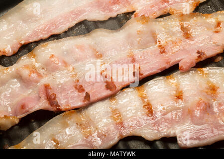 Striata, unsmoked pancetta UE da un supermercato fritti su un George Foreman riducendo il grasso Grill utilizzando il grasso naturale della pancetta. Regno Unito Foto Stock