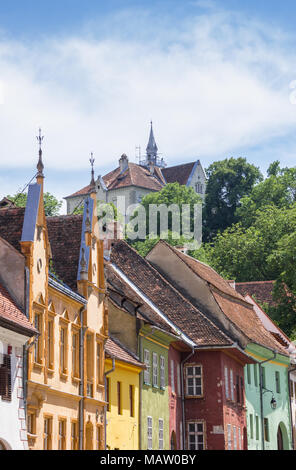 Scuola sulla collina sopra case colorate in sighisoara, Romania Foto Stock