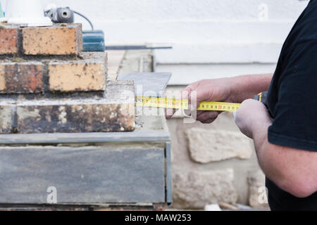 L'installatore le misure e le mette segni per il taglio e la posa di un tile Foto Stock