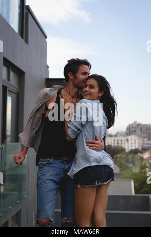 Giovane che abbraccia ogni altra nel balcone Foto Stock