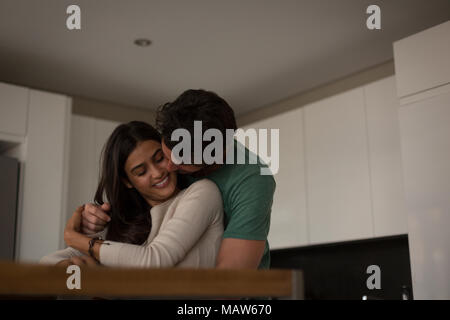 Giovane che abbraccia ogni altro in salotto Foto Stock