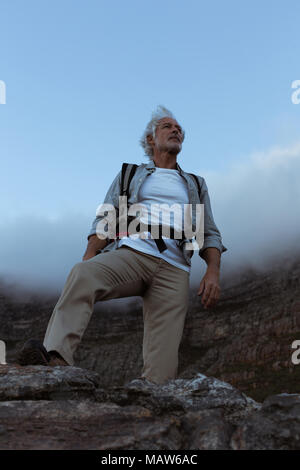 Senior escursionista in piedi sulla cima della montagna Foto Stock