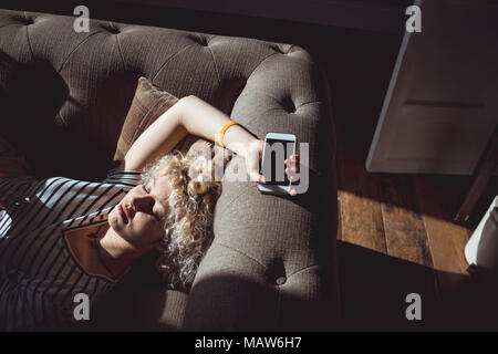Donna che dorme nella stanza vivente Foto Stock