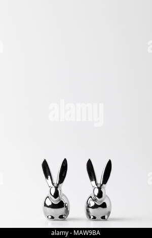 Due statuette di conigli pasquali su bianco Foto Stock