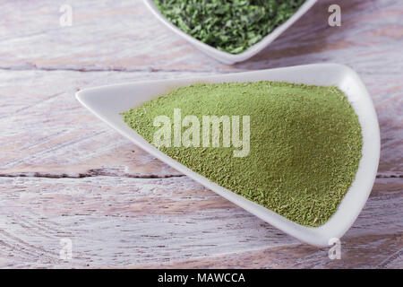 Polvere di moringa in cucchiaio su sfondo di legno Foto Stock