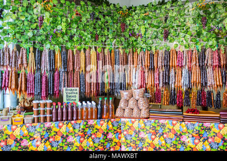 Churchkhela un tradizionale georgiano Candy fatta di uva o di altri succhi di frutta, le mandorle, le noci e la farina avvitato su una stringa venduti nel mercato Street Foto Stock