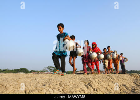 Khulna, Bangladesh - Ottobre 08, 2014: i bambini del Bangladesh trasportare acqua potabile dopo lo raccolgono da una fresca sorgente di acqua in corrispondenza della zona costiera di Khulna, Foto Stock