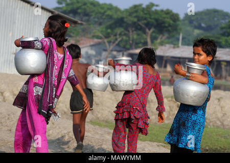 Khulna, Bangladesh - Ottobre 08, 2014: i bambini del Bangladesh trasportare acqua potabile dopo lo raccolgono da una fresca sorgente di acqua in corrispondenza della zona costiera di Khulna, Foto Stock