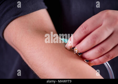 Close up della giovane donna con se stessa le mani prendendo un campione di sangue con una siringa Foto Stock