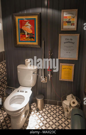 Un ben attrezzato bagno per disabili in uno stile francese ristorante con poster colorati Foto Stock