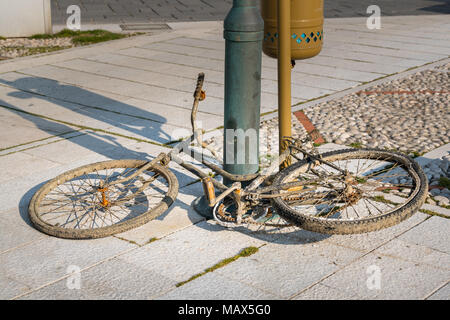 Una vecchia bicicletta danneggiato da acqua di mare giacente sul terreno, porto di Cherso Croazia Foto Stock