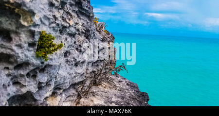 Paesaggio tropicale con rocce contro oceano turchese su Isole Turks e Caicos Foto Stock