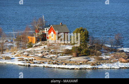 Isola rocciosa con case in legno in arcipelago di Helsinki. La molla Foto Stock