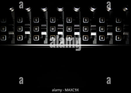 Studio audio mixer volume cursori e compone il bordo illuminato su sfondo nero Foto Stock