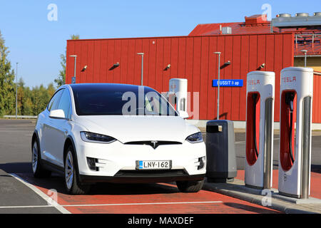 TOIJALA, Finlandia - 24 settembre 2017: Bianco Tesla Model X SUV elettrico collegato al compressore di stazione. Foto Stock