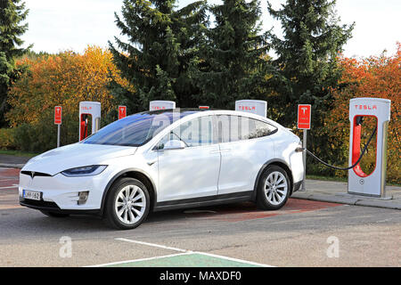 PAIMIO, Finlandia - 15 ottobre 2017: Bianco Tesla Model X crossover elettrico SUV carica la batteria di Tesla Supercharger stazione di Paimio. Foto Stock