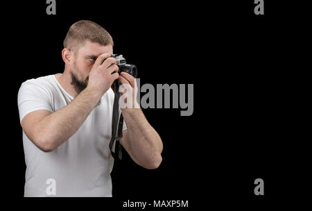 L'uomo hipster, tenendo una fotocamera vintage nelle mani. Con copia spazio. Foto Stock