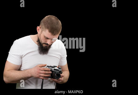 L'uomo hipster, tenendo una fotocamera vintage nelle mani. Con copia spazio. Foto Stock