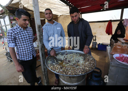 Khan Younis, Striscia di Gaza, Territori palestinesi. 4 apr, 2018. Gli uomini palestinesi di preparare il cibo per i dimostranti durante una tendopoli di protesta, al confine Israel-Gaza, rivendicano il diritto di tornare in patria, in Khan Younis nel sud della striscia di Gaza il 4 aprile 2018 Credit: Ashraf Amra/immagini APA/ZUMA filo/Alamy Live News Foto Stock