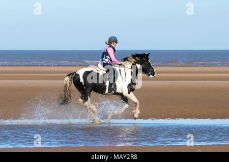 Ainsdale Beach, Southport, Merseyside. 5 aprile 2018. Il sole e cieli blu sono le condizioni meteo perfette per Josie Williams per prendere il suo amato cavallo, 15 anni, truffa per un galoppo lungo le sabbie dorate e la marea sulla spiaggia Ainsdale in Southport, Merseyside. Credito: Cernan Elias/Alamy Live News Foto Stock