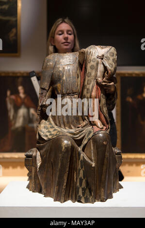 Bonhams, New Bond Street, Londra, Regno Unito. Il 5 aprile 2018. L'asta internazionale, casa Bonhams è quello di vendere la collezione d'arte privata del celebre scultore e artista, Antón Casamor. Il contenuto di una villa catalana la vendita si svolgerà a Londra Mercoledì 11 Aprile. Foto: personale Bonhams esaminare decapitati xv secolo policromo scolpito la Madonna e il bambino. Credito: Malcolm Park/Alamy Live News. Foto Stock